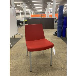 Angle view of Pre-owned HON armless side chair has red body and (4) metallic silver post legs. -B GRADE-