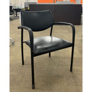 Angled view Pre-owned Gunlocke side chair has a black leatherette seat and back. With black loop arms and (4) post legs. -B GRADE-